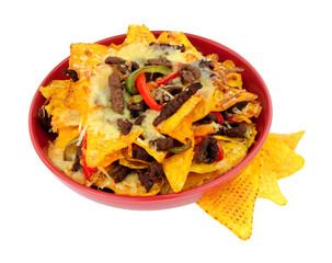 Bowl of beef and cheese nachos with red and green peppers isolated on a white background