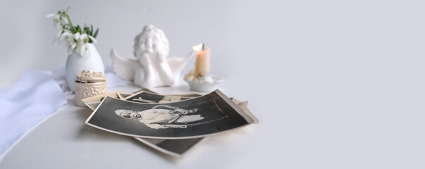 stack of vintage photos, baby photography of 1960, candle is lit, first spring flowers, snowdrop,...