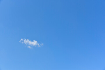 Small, fluffy and lonely clouds in the blue sky copy space