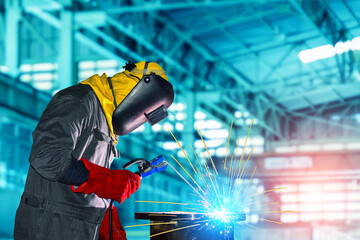 Industrial worker welding with spark on metal piping using Arc welder and wear equipment protection mask