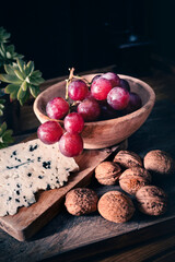 Grapes with blue cheese and walnuts, the perfect combination for a delicious snack or dessert. Dark food photography
