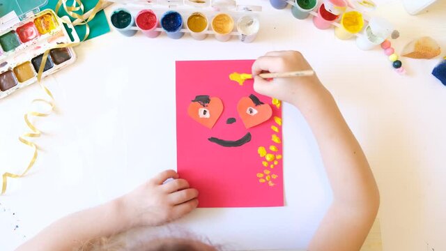 Child making homemade greeting card from paper. Gift for Mothers day, Fathers day, Birthday or Valentines day.  Kid craft. Home Education game. Early development concept