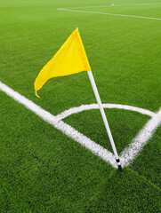 Yellow flag on the corner of a football field. Place for a corner kick on a soccer ball. White line...