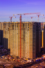 construction of a multi-storey building, tower cranes, building materials and dirt on the site