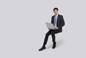 handsome and friendly face asian businessman smile in formal suit his using computer laptop on white background studio shot.