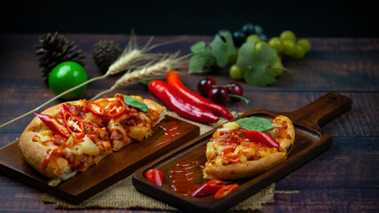 Delicious Italian Pizza with Red Chili And draw chili sauce on the wooden plan where the pizza is placed On a dark wood floor