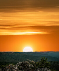 Fototapeta na wymiar Orange sunset with text space over the mountain range