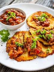 Potato pancakes with vegetable stew on wooden table