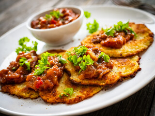 Potato pancakes with vegetable stew on wooden table