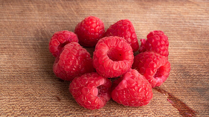 Sweet and delicious raspberries glowing in bright pink and red in a great closeup shot. The tiny strains of hair is clearly visible on the raspberry. Foraging and wild berries concept.