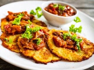 Potato pancakes with vegetable stew on wooden table
