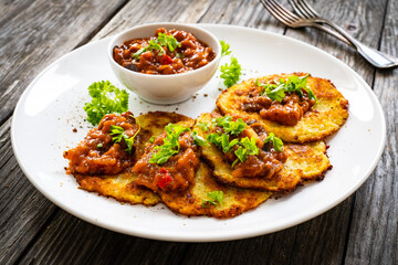 Potato pancakes with vegetable stew on wooden table
