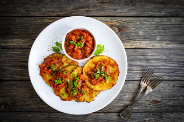 Potato pancakes with vegetable stew on wooden table