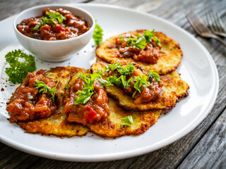 Potato pancakes with vegetable stew on wooden table