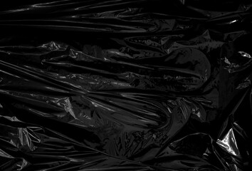 a transparent plastic wrap on black background. realistic plastic wrap texture for overlay and effect. wrinkled plastic pattern for creative and decorative design. - obrazy, fototapety, plakaty