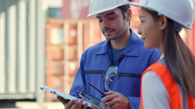 Asian and caucasian professional engineer Holding Clipboard and tablet Checking Shipping Cargo Freights In Front Of Cargo Containers In Shipping Container Yard logistic and Distribution business ideas