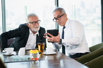 senior couple business drinking coffee and show trading