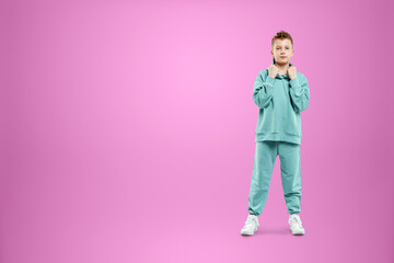 Portrait, cute stylish boy in a blue suit on a pink background. Studio portrait of a child, modern design, trendy background, turquoise. Copy space.