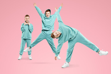 Portrait, cute stylish boy in a blue suit on a pink background. Studio portrait of a child, modern design, trendy background, turquoise. Copy space.