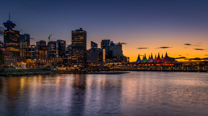 Obraz premium Sunset over the Harbor and the Sails of Canada Place, the Cruise Ship Terminal and Convention Center on the Waterfront of Vancouver, British Columbia, Canada
