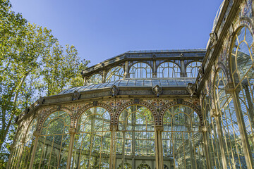 Fototapeta na wymiar Crystal Palace (Palacio de Cristal) in the Public Retiro Park in Madrid. Crystal Palace built in 1887 to exhibit flora and fauna from the Philippines. Madrid, Spain.