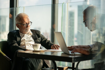 executive businessman working on laptop in cafe