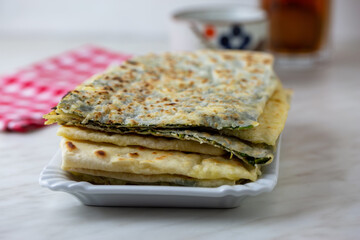 Traditional Turkish food gözleme with cheese and spinach. Turkish pancake gozleme concept on the white background.
