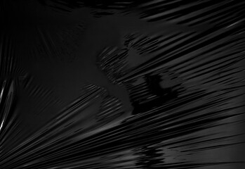 a transparent stretch plastic wrap on black background. realistic plastic wrap texture for overlay and effect. wrinkled plastic pattern for creative and decorative design.