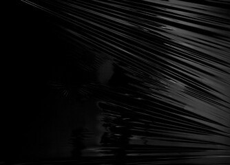 a transparent stretch plastic wrap on black background. realistic plastic wrap texture for overlay...