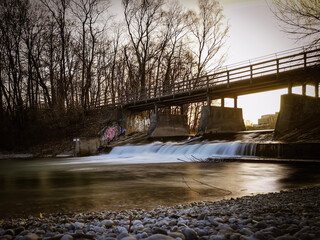 Fluss Isar in München am Flaucher mit Brücke und Wasserfall
