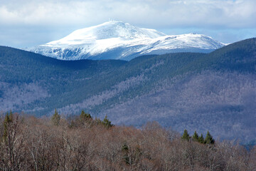 Scenic view along Bear Notch Road in White Mountains of New Hampshire. Rugged snow-capped summit of Mount Washington with weather observatory antennas at top of mountain.