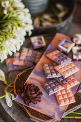 Obraz na płótnie Canvas Assortment of luxury colored bonbons. Exclusive handmade chocolate candy. Springtime, Womans Day, Valentines Day concept. Pink and violet with dark chocolate flower