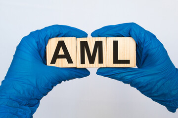 A doctor wearing gloves holds wooden cubes with the inscription AML, medical concept