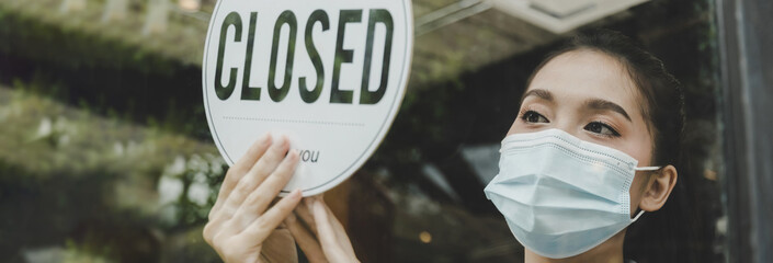 wide banner. friendly waitress woman staff wearing protection face mask turning Closed sign board reopen after coronavirus quarantine is over in cafe, restaurant, take away, food and drink concept