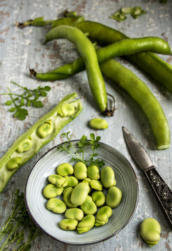 dicke gr&uuml;ne bohnen in einer sch&uuml;ssel mit schoten und messer