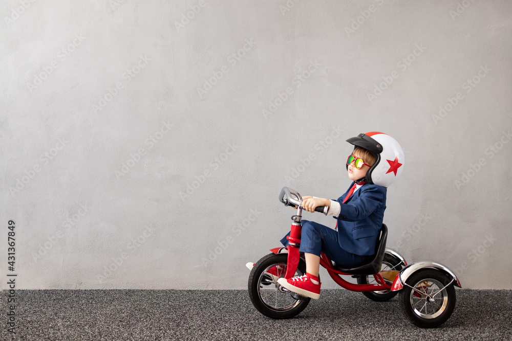 Sticker happy child wearing suit riding vintage bicycle