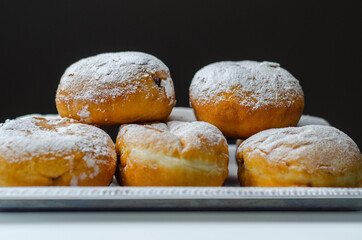 Berliner Pfannkuchen, a German donut, traditional yeast dough deep fried filled with chocolate cream and sprinkled with powdered sugar