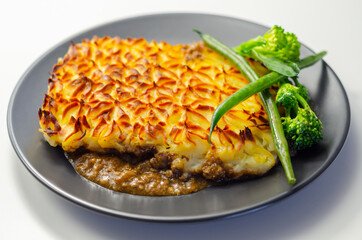 Tender minced lamb with garden veg in a hearty gravy beneath butter mash, typical Shepherd's pie