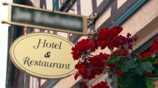 Lockdown Of Geraniums On The Side Of A Historic German Building With A Focal Transition To A Hotel And Restaurant Sign In The Background - Rhine Region, Germany