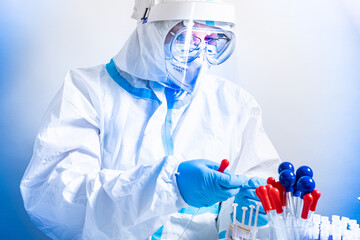Portrait of scientist or doctor working with blood. Covid 19 blood test concept. Glass pipette and...