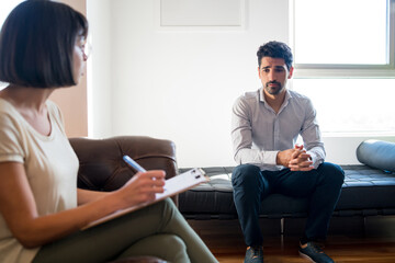 Obraz premium Psychologist taking notes during therapy session.