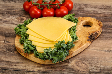 Sliced Gauda cheese over board