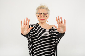 portrait of a beautiful stylish woman aged in glasses on a white background with a hand gesture 