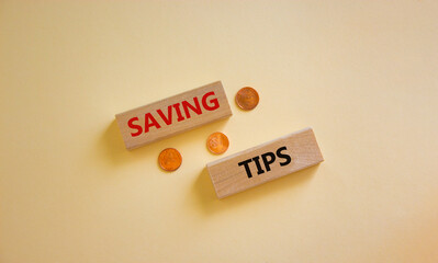 Saving tips symbol. Wooden blocks with words 'saving tips' on beautiful white background. Metallic coins. Business and saving tips concept. Copy space.