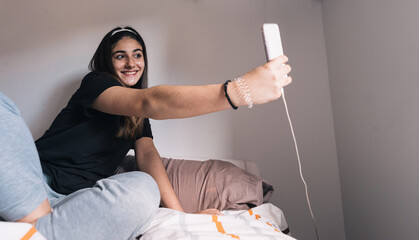 brunette teen taking selfie in the bedroom