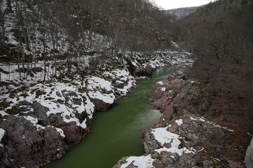 Snowy mountain river on sunset. Green color water