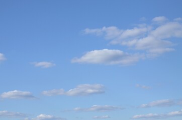 We see white, spring, small, rare clouds against the blue sky