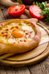 ajara Khachapuri with cheese and egg georgian kitchen on old wooden table close up