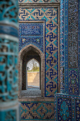 View of the mausoleums and domes of the historical Shakhi Zinda cemetery through the arched gate, Samarkand, Uzbekistan.