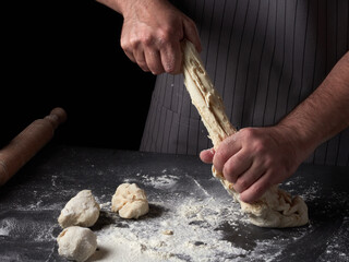 Photo of flour and men hands with flour splash. Cooking bread. Kneading the Dough.